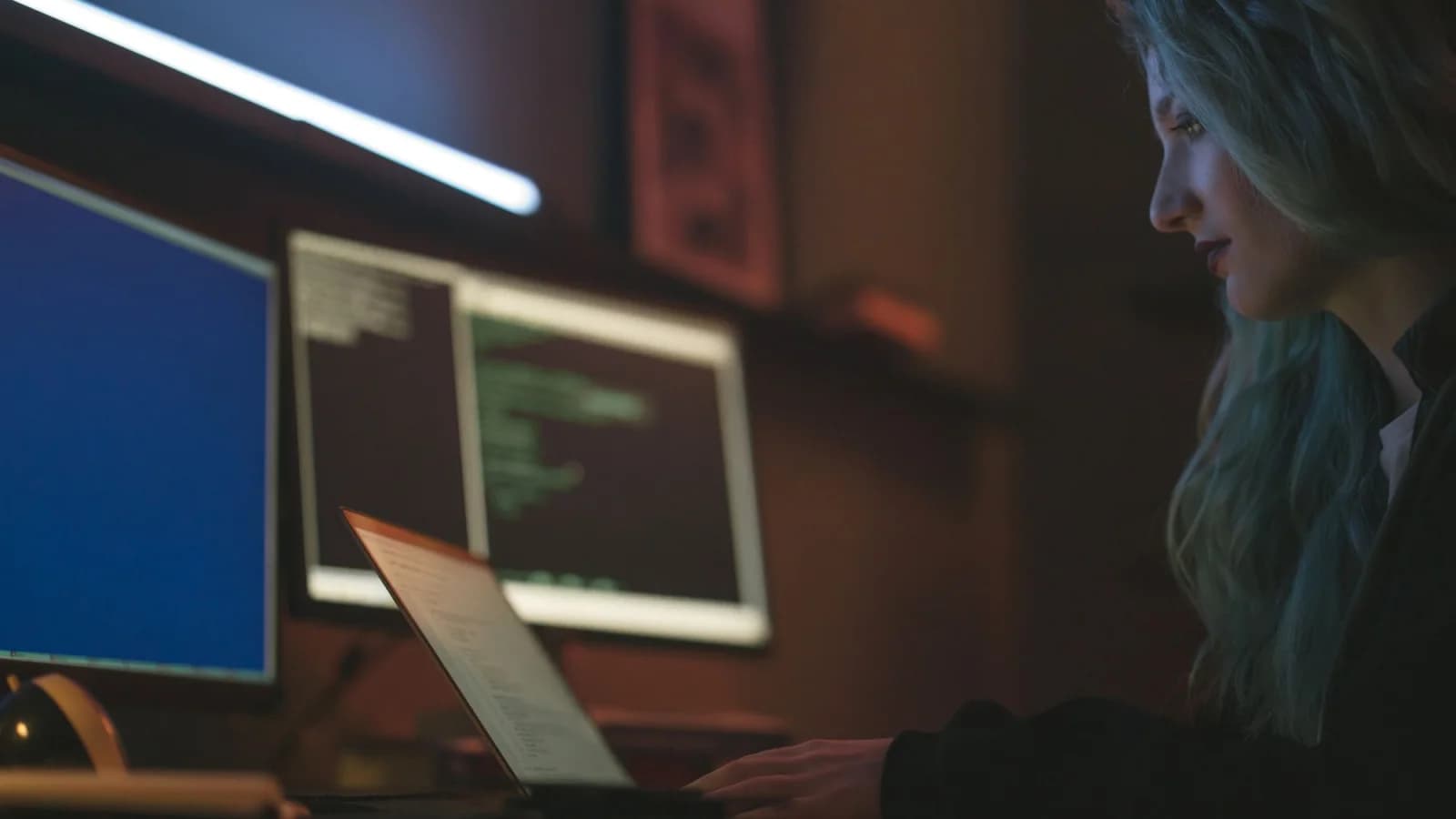 Специалист работает за ноутбуком и мониторами в технологической среде